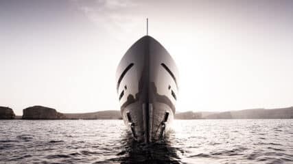 A sophisticated vessel on serene waters, preparing for luxury yacht sales with expert guidance from Edmiston.