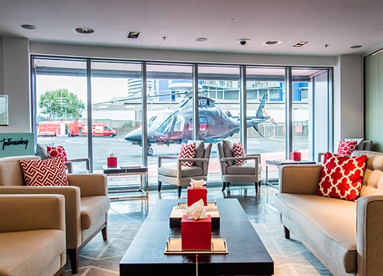 Luxury lounge view at London Heliport, where a helicopter awaits its passengers for an exclusive yacht transfer.