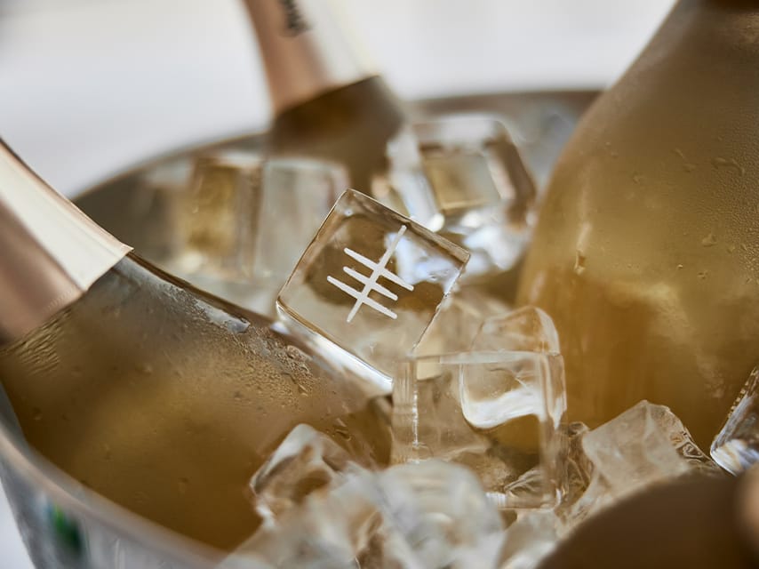 The Edmiston logo is engraved on ice in a champagne bucket at the VIP lounge, elevating the yacht exhibition Monaco with signature drinks and exclusive events.