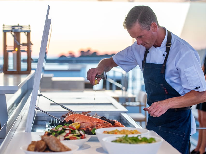 Private chef preparing gourmet food for the ultimate luxury experience on your Formula 1 Abu Dhabi yacht charter.
