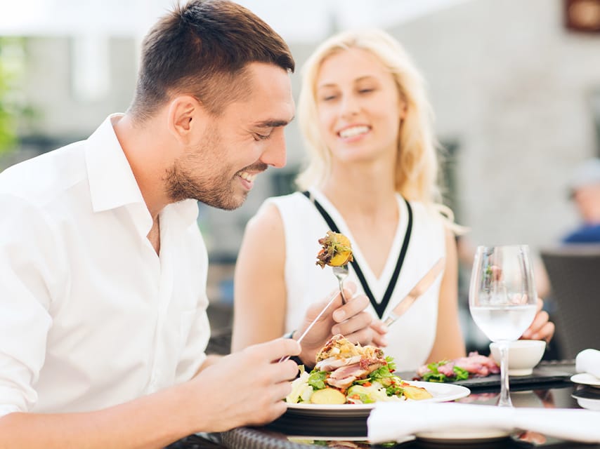 A couple enjoying lunch at an exclusive restaurant arranged by their personal concierge from their Art Basel Miami yacht charter.