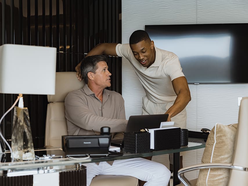 Business partners enjoy a meeting in the onboard office during a corporate yacht charter and yacht team building event.