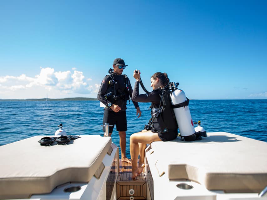 A couple enjoys a private sailing charter, Caribbean waters enticing them to scuba dive and enjoy other fun yacht activities.