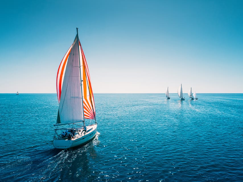 A luxury sailing yacht heads to the starting line of the St. Barths Bucket regatta, ready for an unforgettable race.