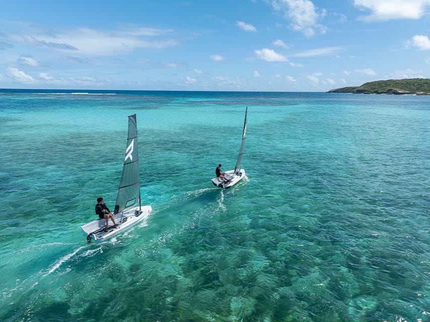 Two Reverso Air sailing dinghies glide over turquoise water, luxury water toys included in a St Barths Bucket yacht charter.