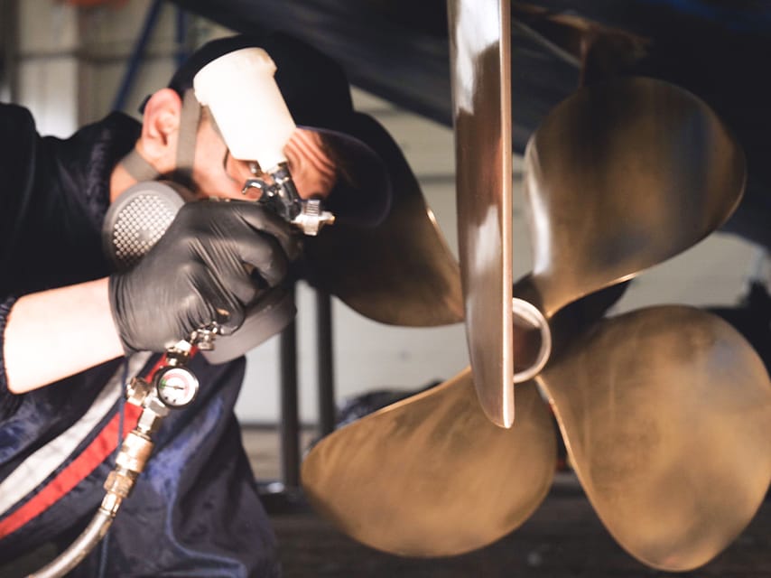 Technician performing routine propeller maintenance as part of a yacht maintenance schedule to ensure optimal performance.