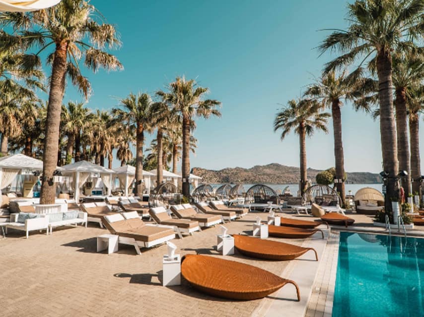 Beautiful rattan loungers line the pool at Cabana Mare Beach Resort, Crete, an ideal stop on your luxury yacht charter, Greek islands.
