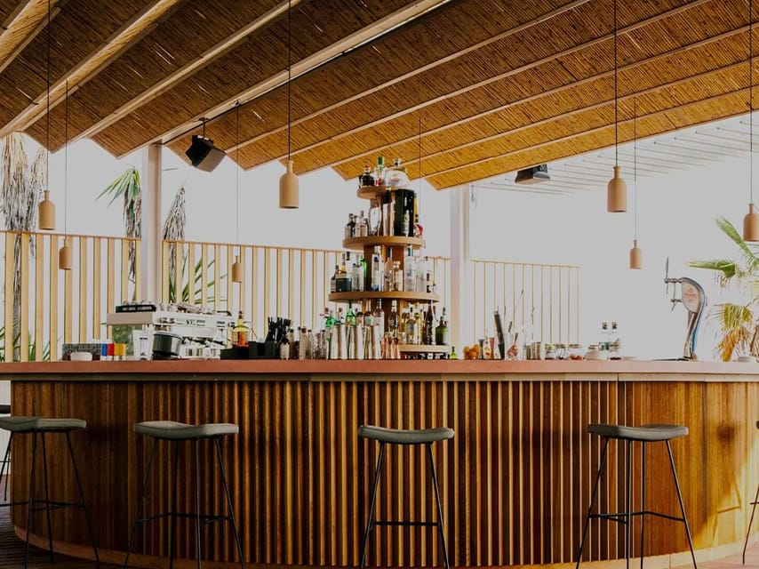 Pazuzu Corfu’s beautiful wooden beach bar offers sunset cocktails and glamorous evenings, making it a top stop on a private yacht charter in Greece.