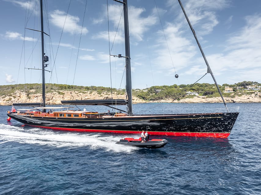 The sailing yacht Maximus, a highlight of the Monaco Yacht Show 2025, motors to the mega yacht show in Port Hercule accompanied by a tender.