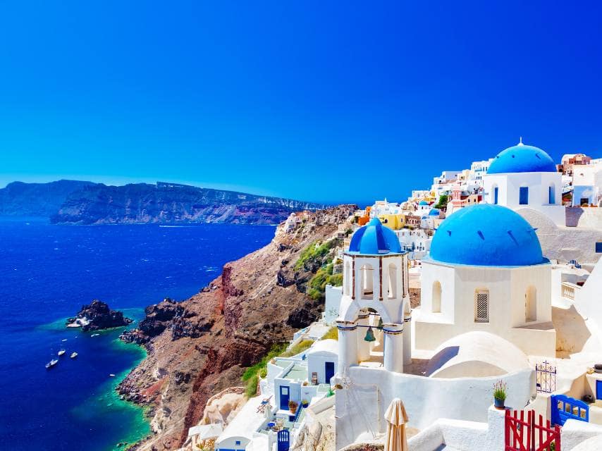 Stunning view of Santorini’s blue-domed houses and sparkling waters, the crown jewel of yacht holidays, Greek islands.