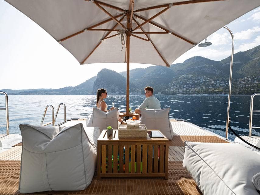 Peaceful moment on the lower deck as a couple admires Aegean views, part of a luxury Greek island hopping trip