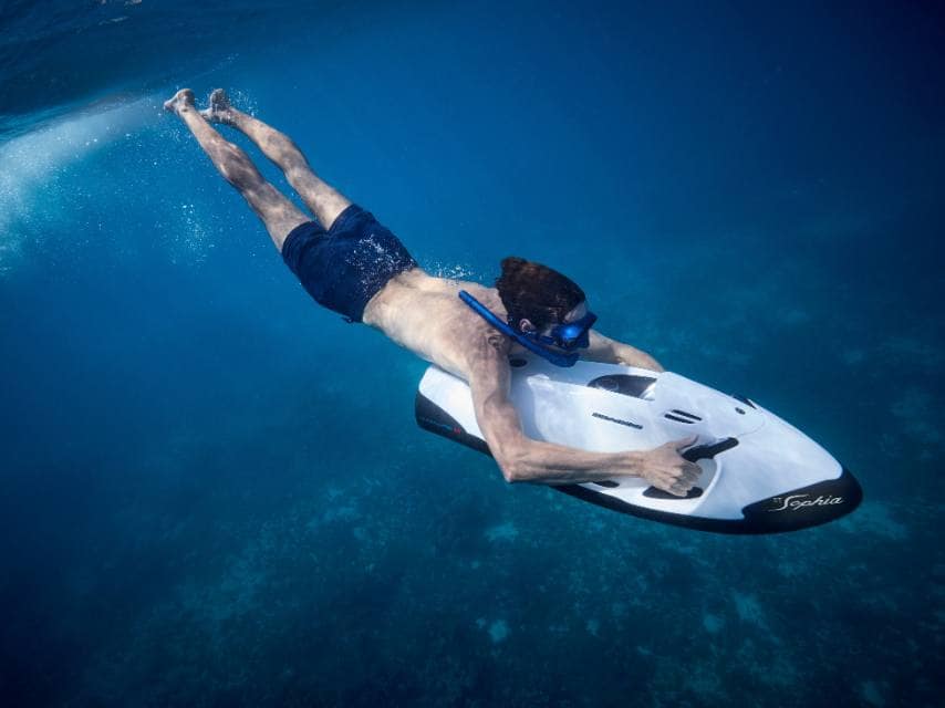 An underwater scooter dives through coastal caves, a thrilling highlight of a luxury Greek island hopping adventure.