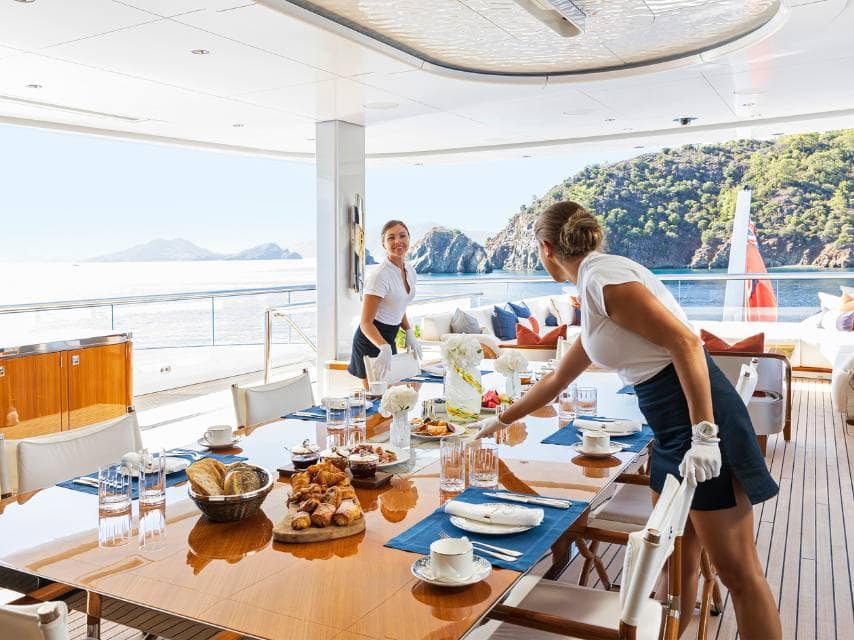 Personalized service at sea during a private yacht Greece island hopping breakfast setup.