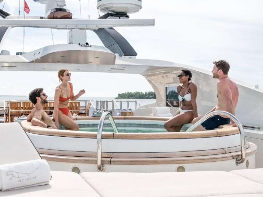 Guests unwind in a private onboard pool during a sun-soaked afternoon during their luxury yacht charter, Greek islands.