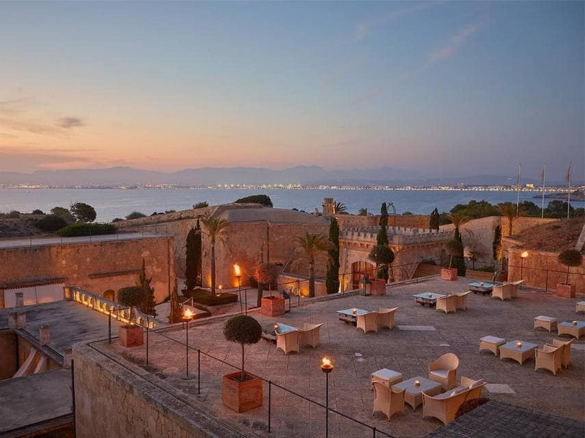 Dine cliffside at sunset with candlelight, part of your luxury yacht charter in the Balearic Islands.
