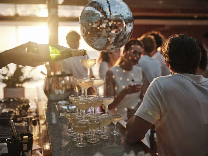 Champagne, dancing, and joy at the disco bar mark the perfect night before heading off to elope on a yacht.