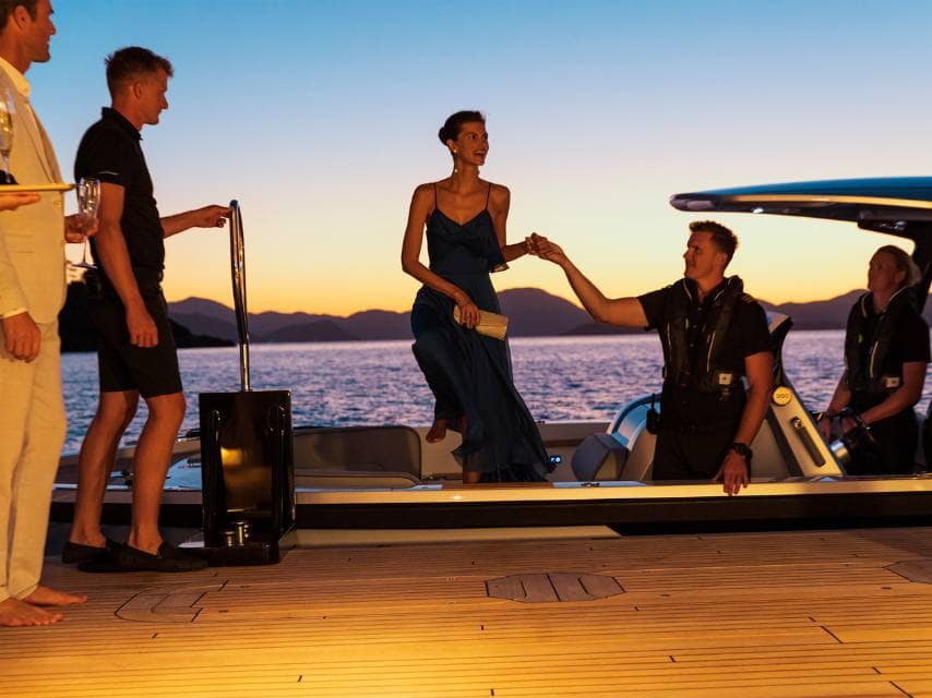 Guests arrive by tender to one of the world’s most exclusive wedding venues aboard a luxury charter yacht.