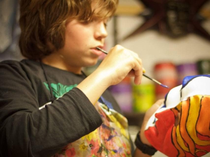 A child participates in mask making in Venice, Italy on a family yacht vacation.