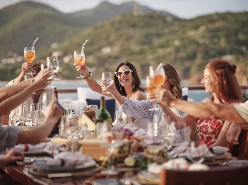 Guests toast the couple on deck during a private yacht charter for wedding festivities.
