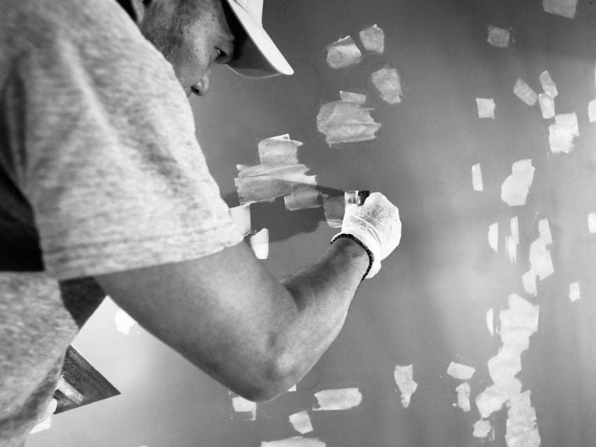 Man painting the yacht at shipyard refit