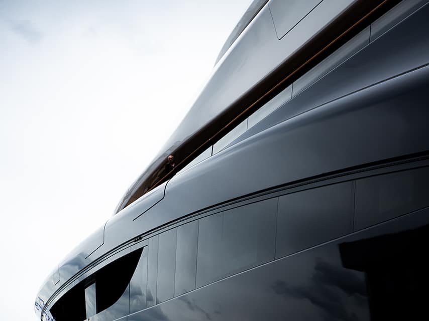 A man aboard the Feadship Van Lent 821 yacht, featuring slide-out balconies and cutting-edge design.