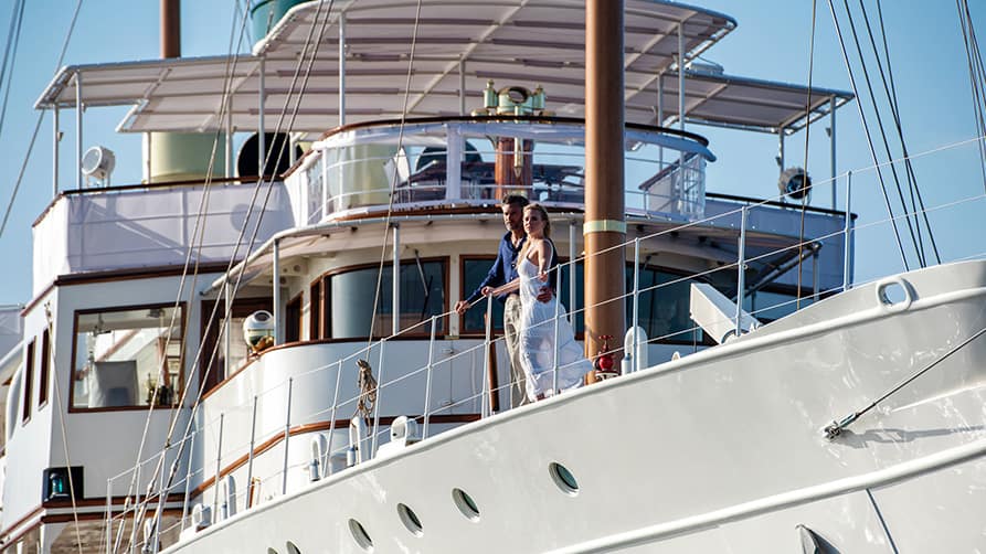 A couple relishes a private superyacht experience, guided by an Edmiston mega yacht marketing expert.
