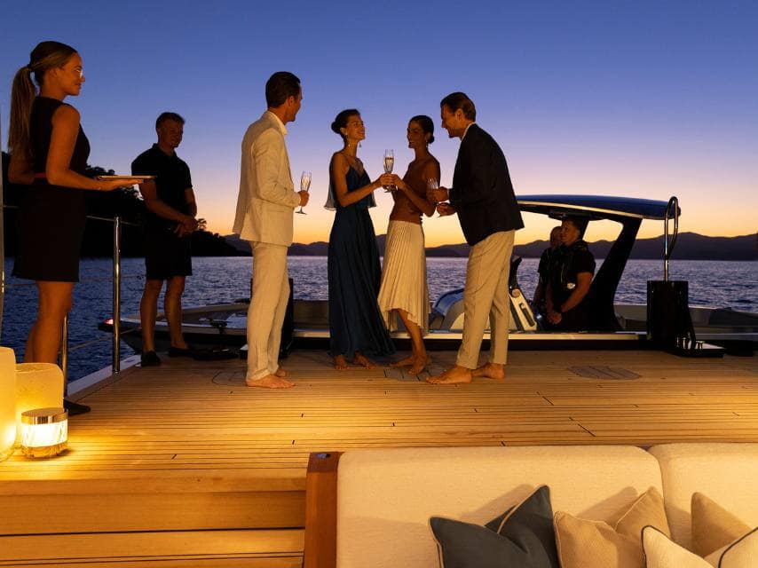 Champagne toasts on deck post-race, elevating the night for Abu Dhabi Luxury Yacht Charter guests.