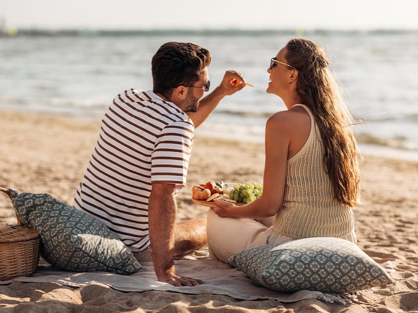 A couple enjoy a secluded beach picnic during one of their most memorable remote luxury yacht holidays.