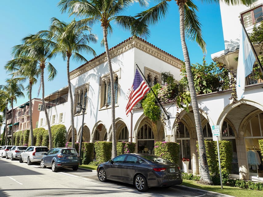 A charming street with palm-lined luxury boutiques, perfect for shopping during the West Palm Beach International Boat Show.