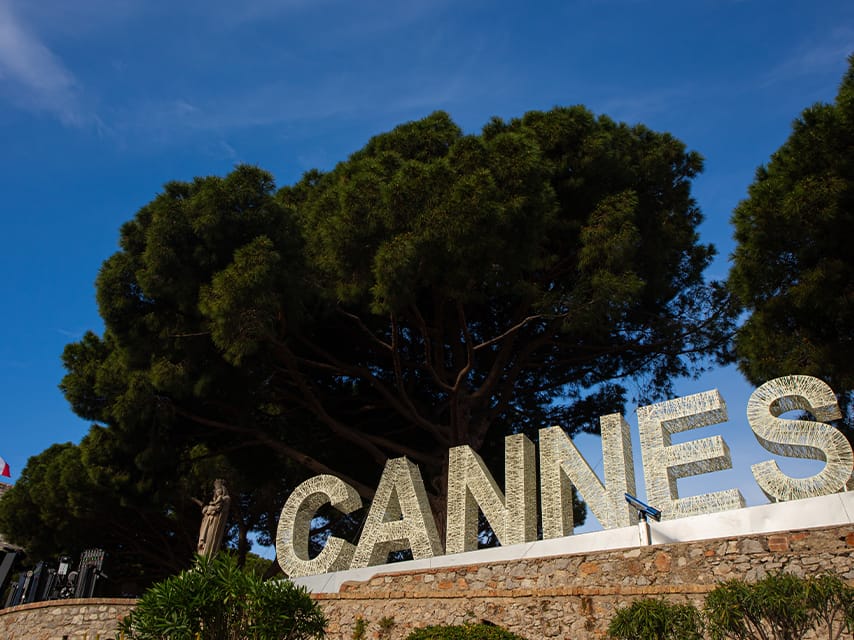 The Cannes Film Festival sign sits atop a stone wall. One of the key luxury events of 2025, enjoy Cannes on a yacht charter.