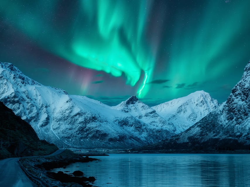 On a luxury yacht charter, Norway fjords tower high above with snowy peaks, as guests enjoy a Northern Lights yacht cruise.