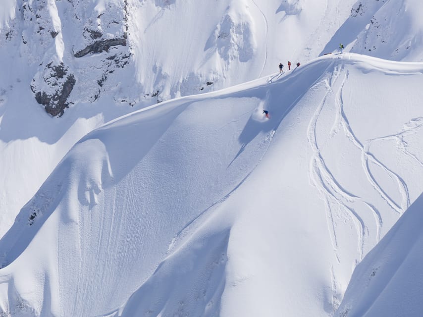 Skiiers enjoy heli skiing Antarctica's slopes, one of the best superyacht experiences from an Antarctica luxury yacht charter.