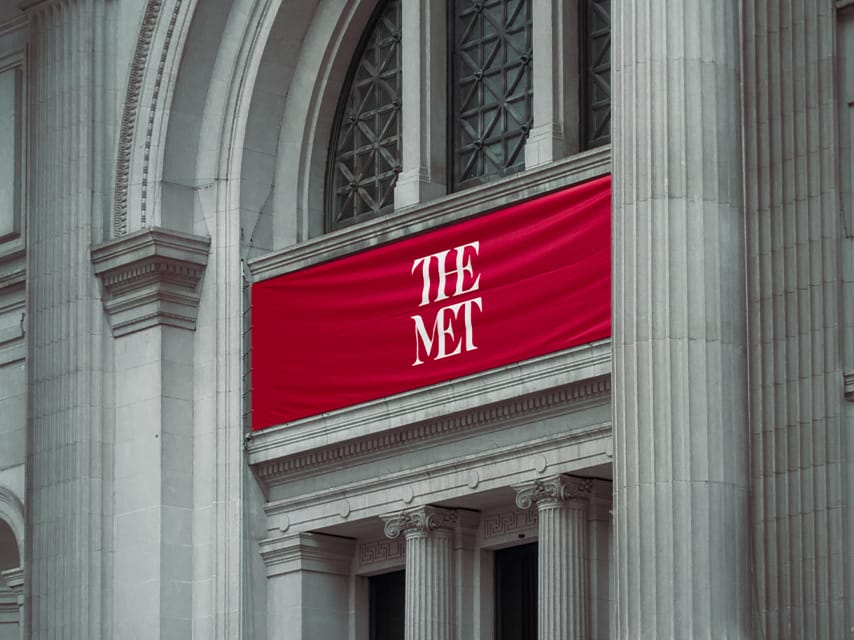 The red and white banner for the Met Gala hangs above the entry way, a pinnacle of luxury events in 2025.