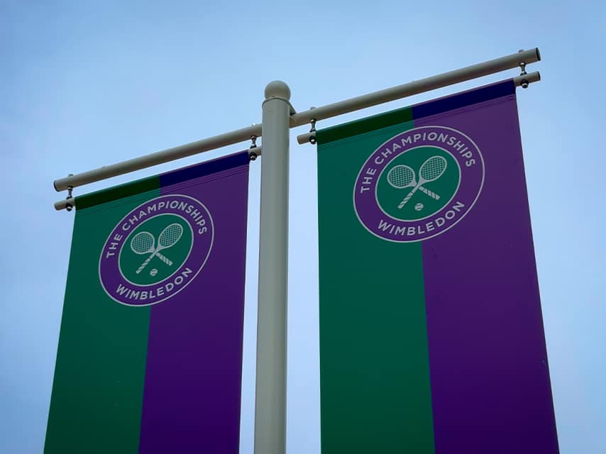 The green and purple Wimbledon Championships banners hang from a post, announcing one of the must-attend luxury events, 2025.