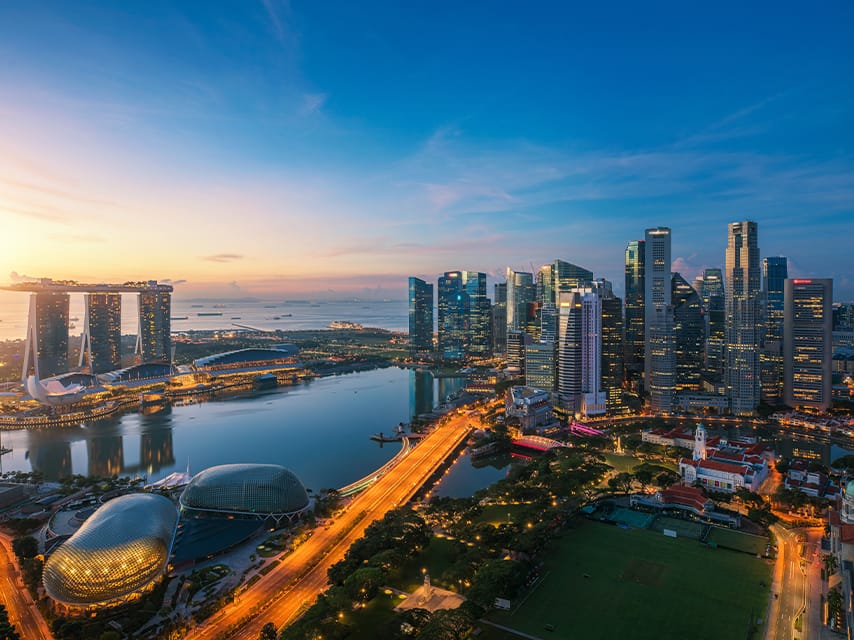 Aerial view of the Singapore city skyline at dusk, an ideal setting for luxury yacht rental, Singapore.