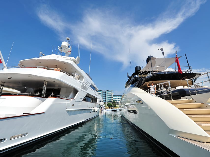 Two superyachts are docked in a marina, their owners are planning to attend the events at the Singapore Boat Show.