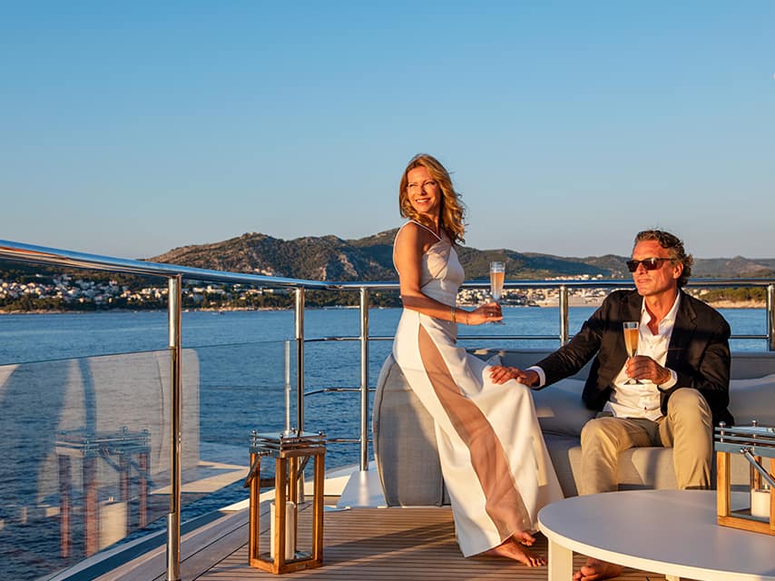 A relaxing moment for a couple aboard their luxury yacht charter, Cannes stunning port views in the distance.