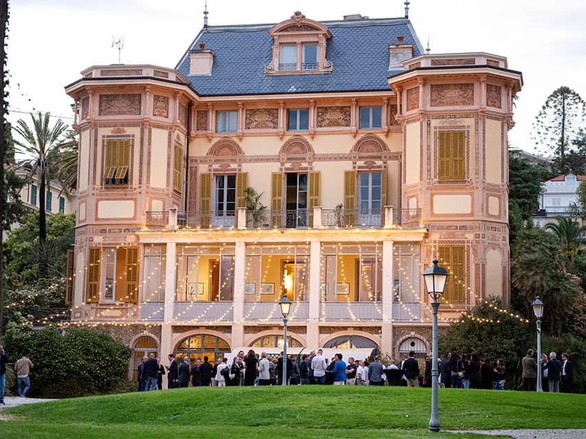MYBA Charter Show elite industry professionals network outside a historic villa at Portosole Marina Sanremo during the event.