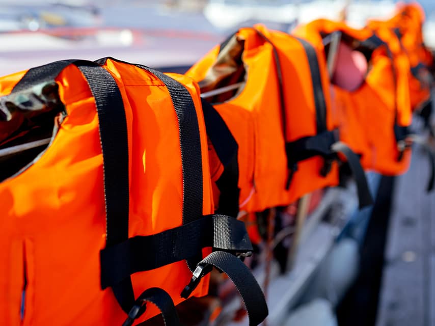 Life jackets are lined up to be carefully inspected during routine checks in Edmiston’s all in one yacht maintenance plan.