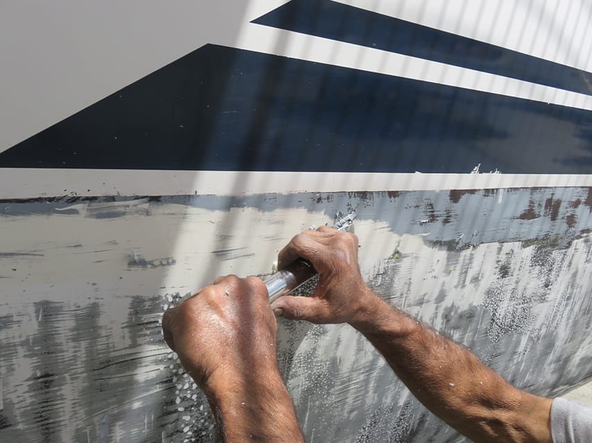A yacht's hull is scraped and re-painted, before adding antifouling as part of luxury yacht maintenance for peak performance.