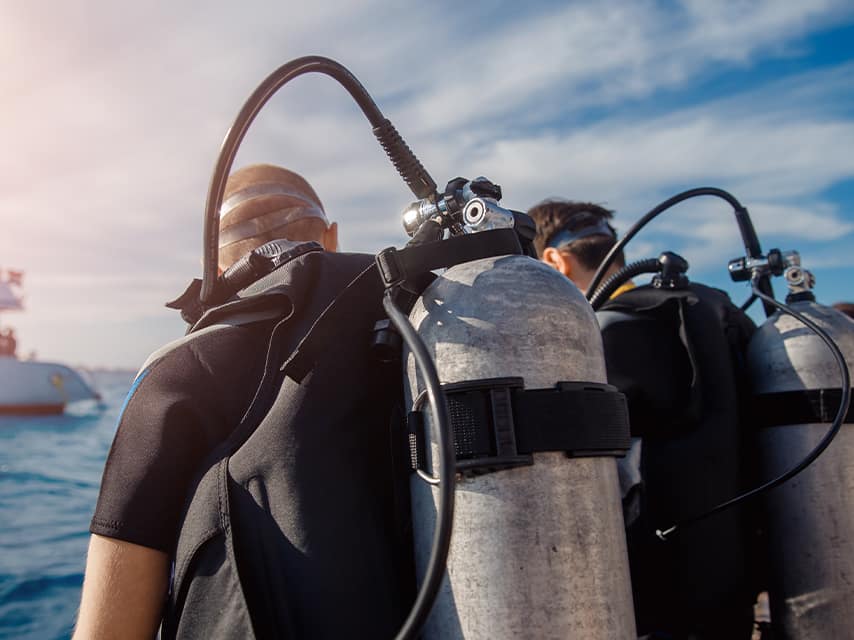 Divers get ready to perform routine equipment checks under the vessel as part of Edmiston yacht maintenance services.