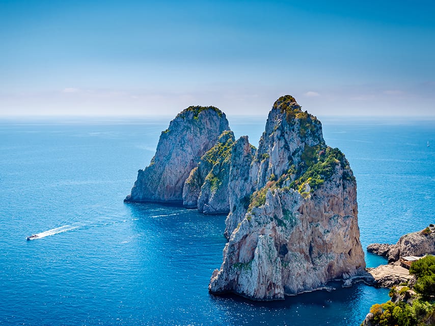 Dramatic views of Capri’s Faraglioni rocks rising out of the sea can be enjoyed on an exclusive Superyacht charter, Italy.