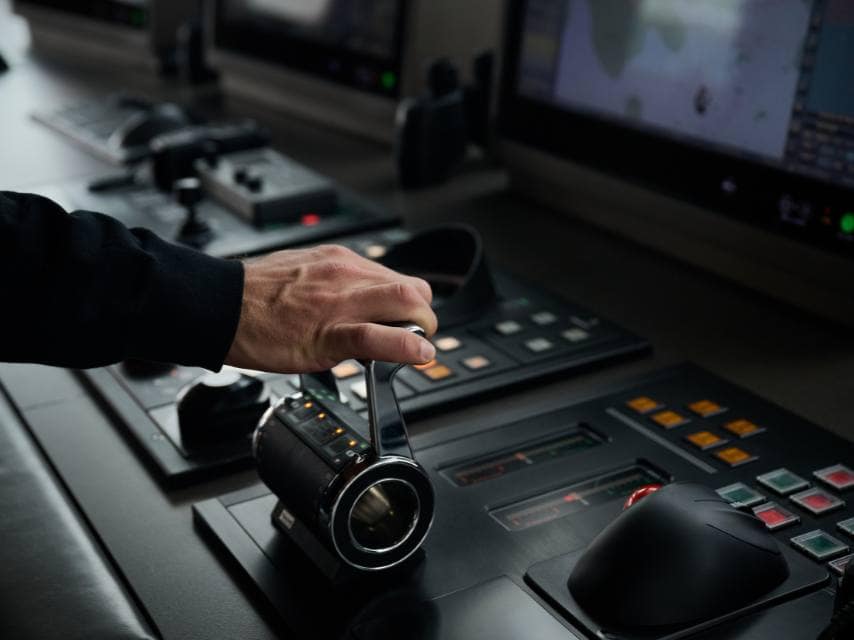 A captain changes gears on a luxury yacht sailing through open waters, operating under an international yacht register.