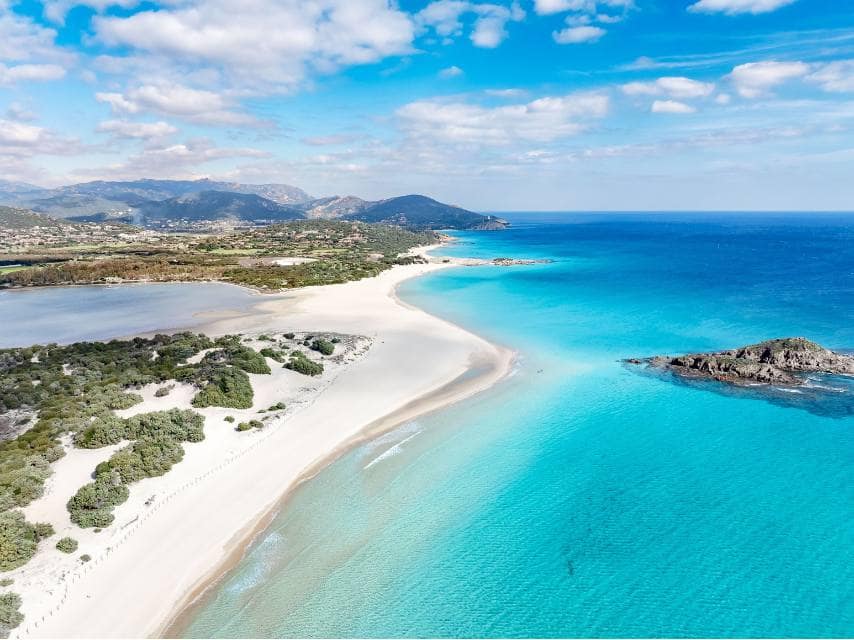 Exploring the coastal shore with crystal-clear waters during a Sardinia scuba diving experience from a private yacht charter.