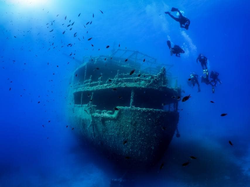Divers explore historic shipwrecks together during a customized scuba diving in Crete yacht charter experience.