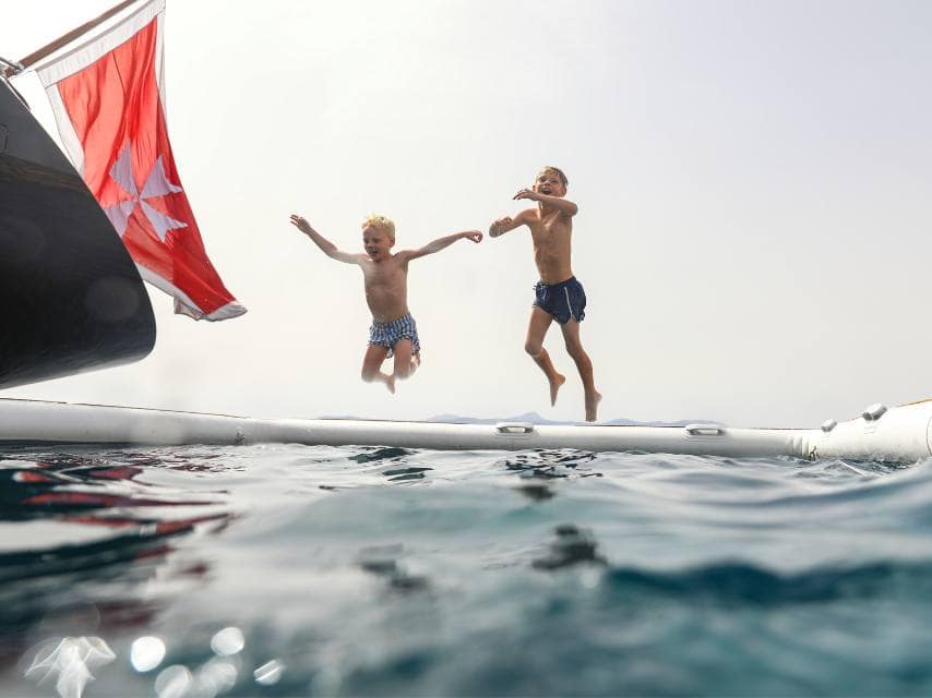 Two boys jump into a pool, one of many carefree moments during luxury family holidays, Mediterranean.