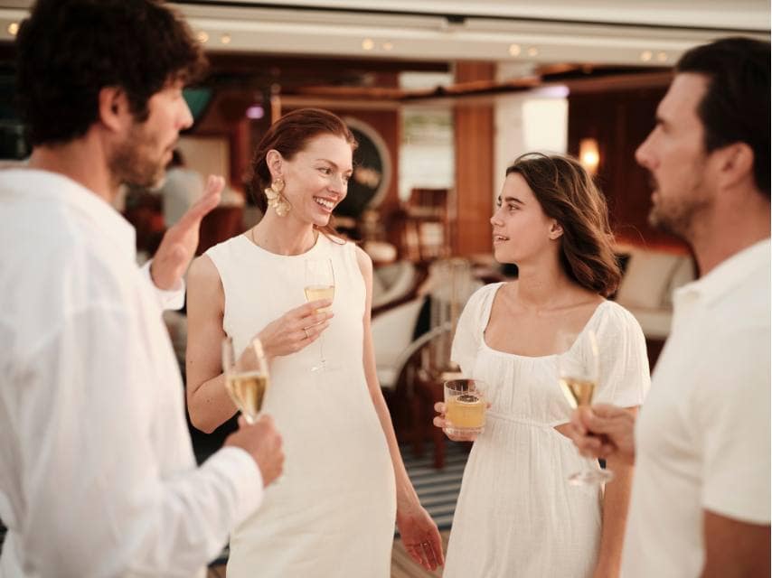 Friends celebrate with champagne in hand aboard SOPHIA yacht — a luxury wedding venues like no other.