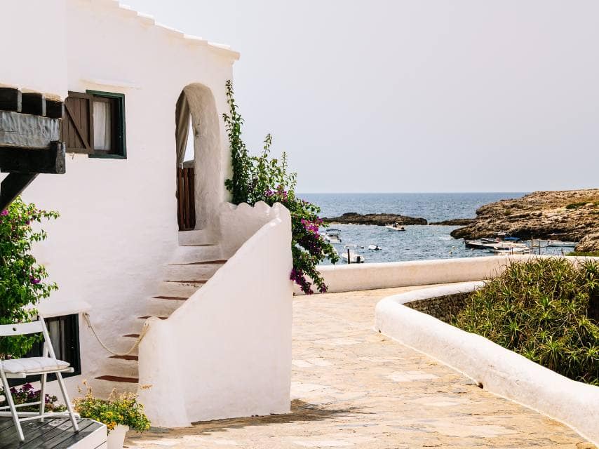 Menorca’s colorful fishing town offers slow living and charm, making it one of the best places to visit in the Mediterranean.