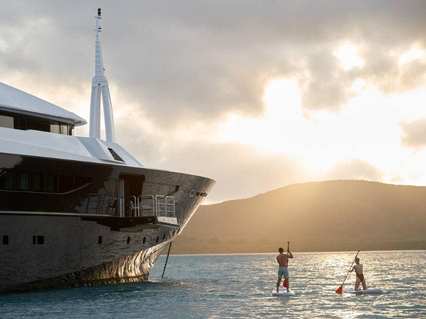 Wellness charter adventure: paddleboarding in crystal-clear waters near superyacht ARBEMA 72.