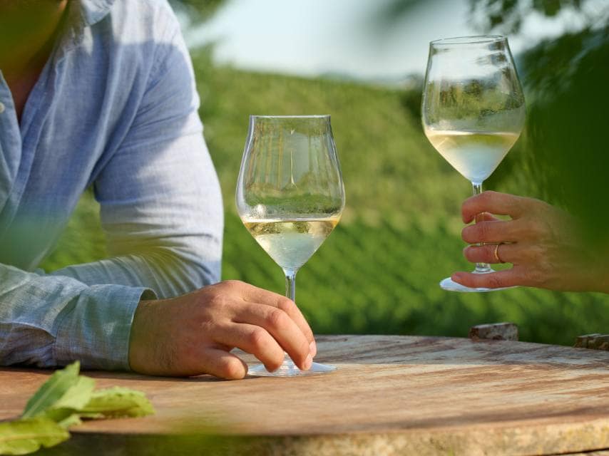 A couple tastes wine on a vineyard tour in Naxos, adding a flavorful stop to their Greek mythology travel.